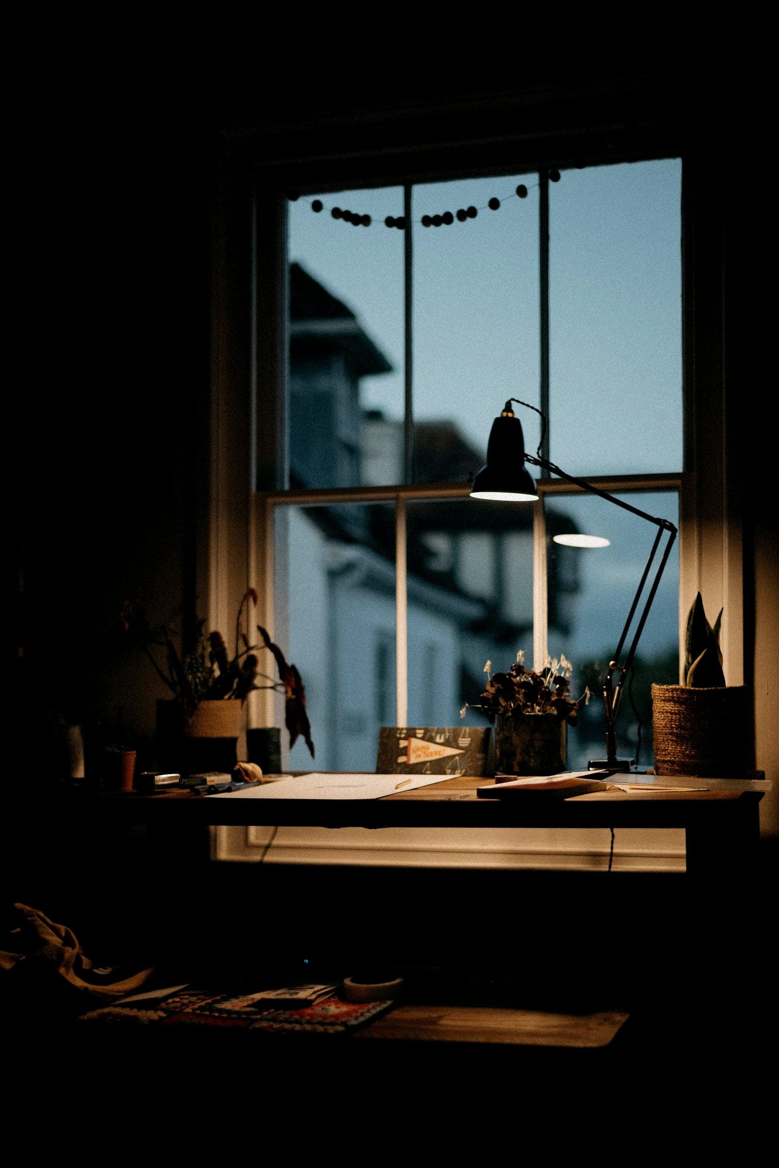 Bureau éclairé par une lampe d’architecte en fin de journée